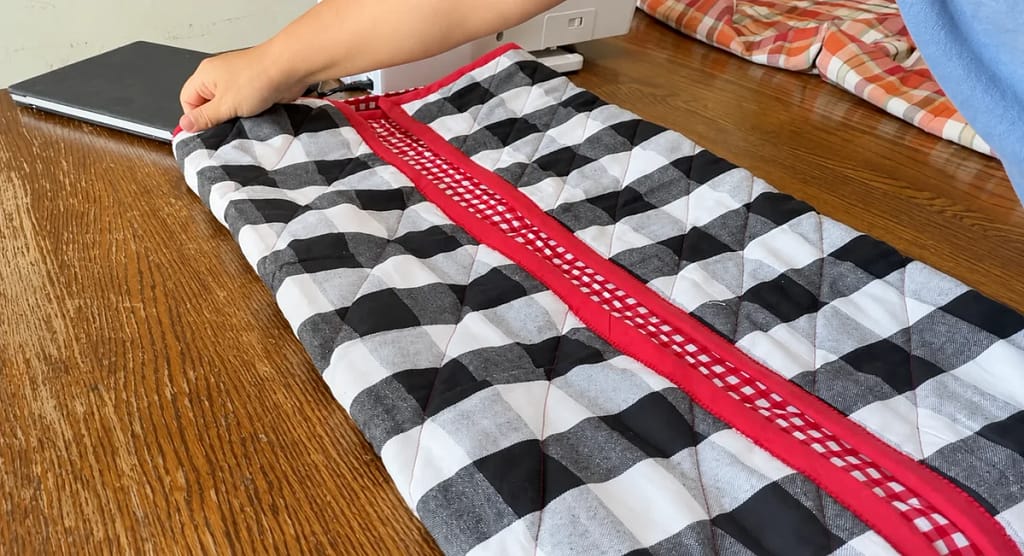 Opposite side folded inward to make a narrow quilt strip.