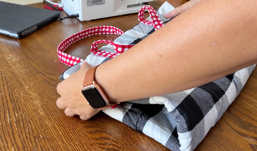 Folded reading quilt brought together with its gingham handles.