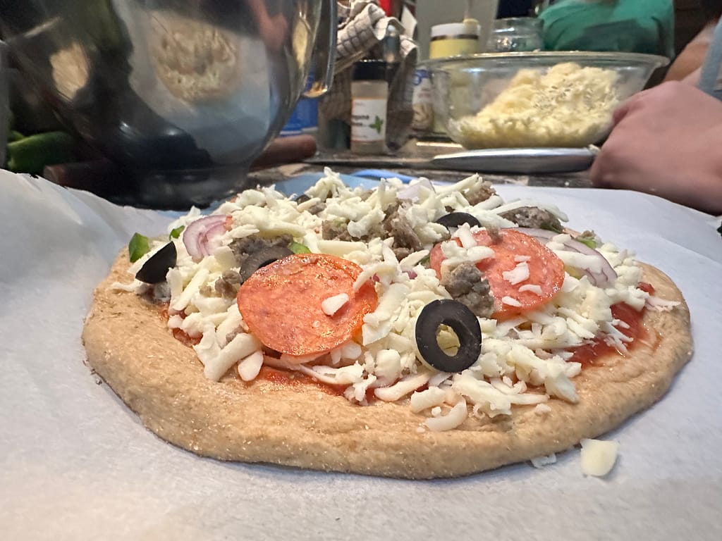 homemade sourodugh pizza with pepperoni, olives, and extra cheese