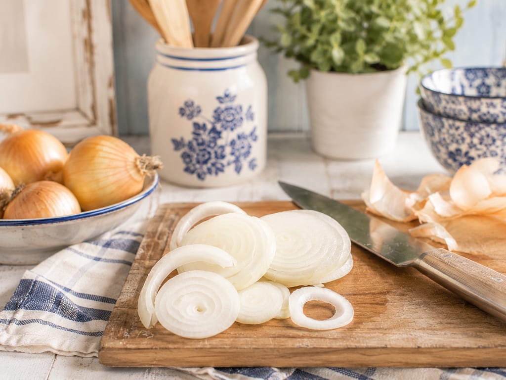 onions sliced on a wood cutting board