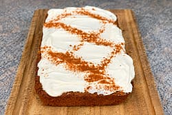 Pumpkin bread baked in a small casserole dish with cinnamon cream cheese frosting