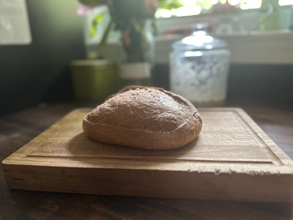 fresh baked loaf of sourdough bread on a cutting board