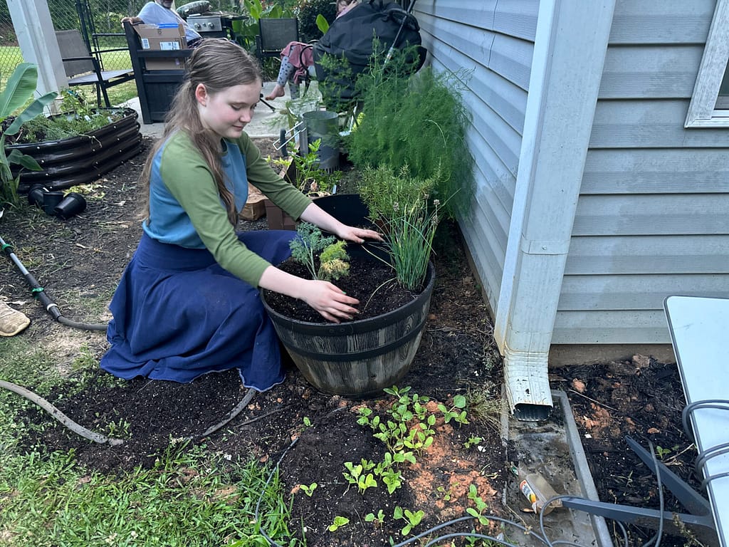 Maddy planting her herb garden in the spring