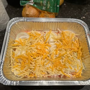 Visalia onions layered with cheese in a casserole dish