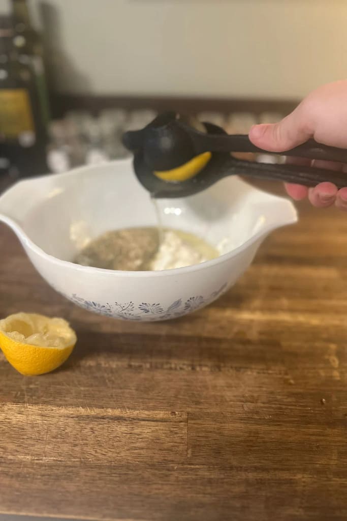 adding lemon juice to the greek chicken marinade