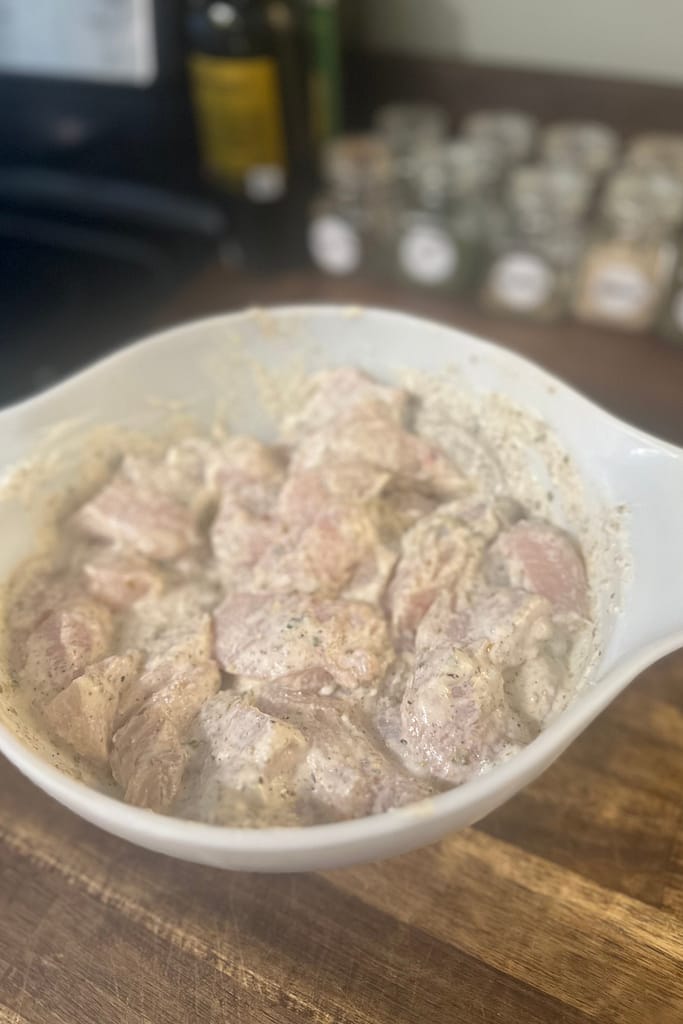 Greek chicken bites tossed in marinade to soak before baking