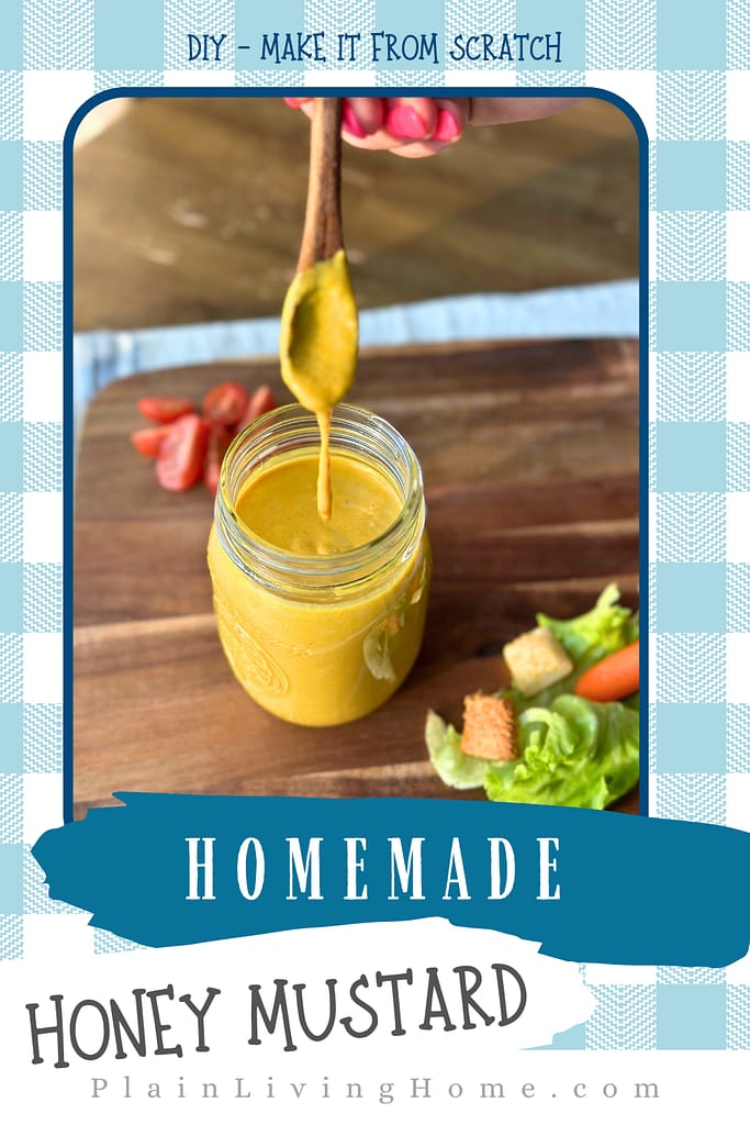a small wooden spoon serving homemade honey mustard dressing from a mason jar
