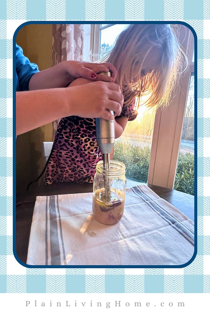 a small child helping make a DIY salad dressing