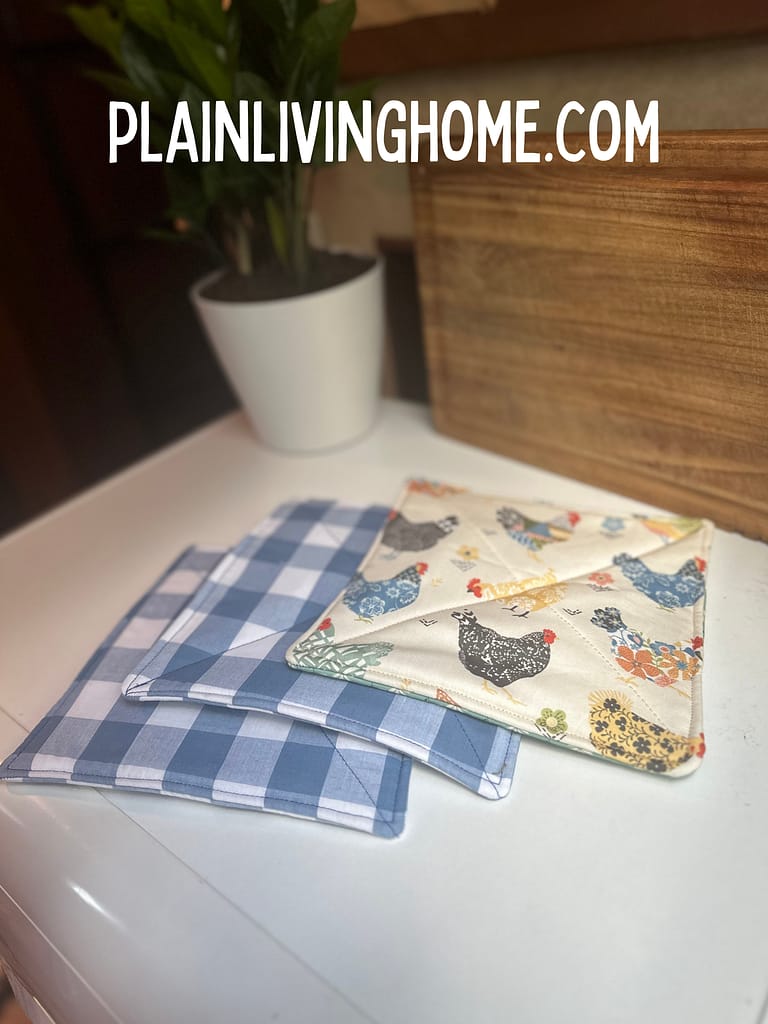 two blue plaid home sewn hot pads and a chicken print hot pads, made with teh simple hot pad tutorial