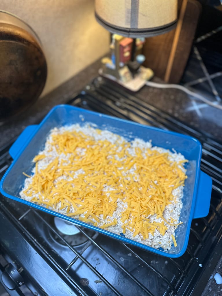 top the chicken casserole with shredded cheese
