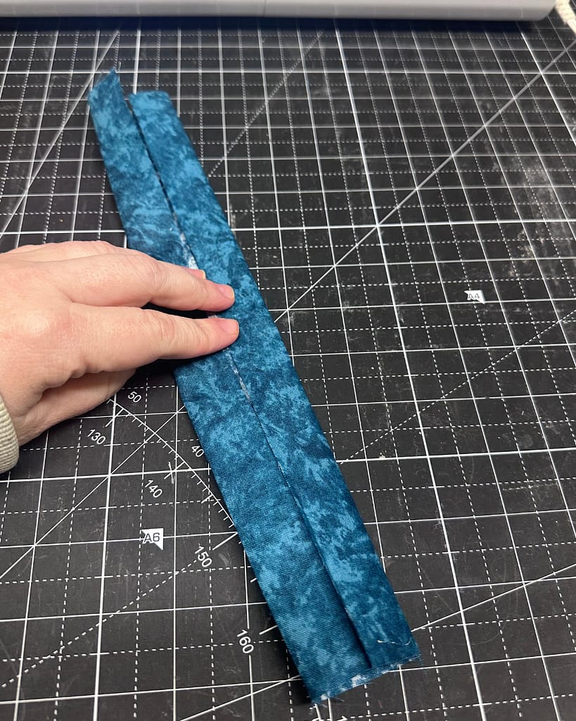 fold the strap piece to tuck all the raw edges inside